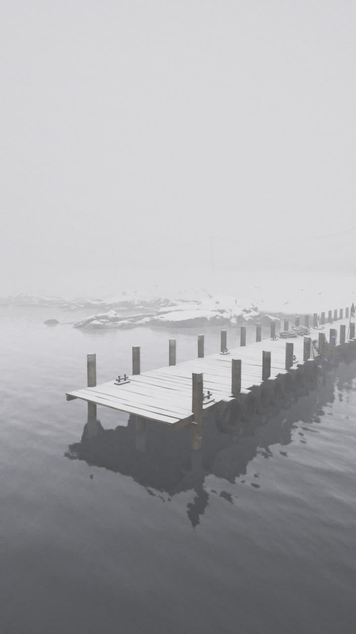Foggy winter morning at a secluded dock near a snowy cabin