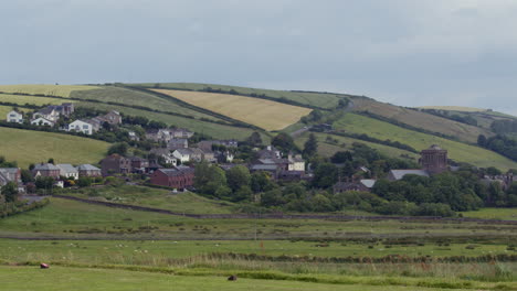 wide shot of the village of st bees, with hills in background. west lake district
