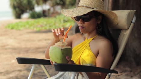 asian woman enjoying the view while drinking fresh coconut juice