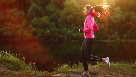 a morning jog in the park near the pond in the sunny rays of dawn, the girl is preparing to mariano and lead a healthy lifestyle