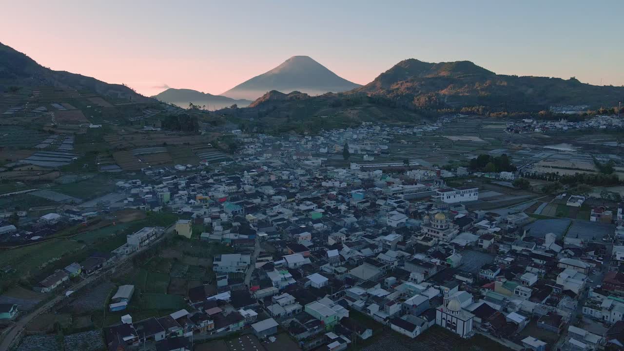 굴곡 된 언덕 의 풍경 에 있는 작은 마을