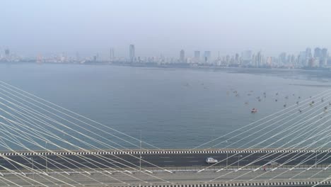 flying over the iconic bandra worli sea link bridge in mumbai revealing the city view in the back