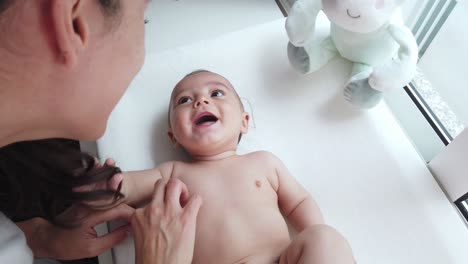 madre alegre y pequeño bebé en casa
