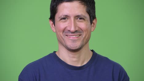 happy hispanic man smiling against green background