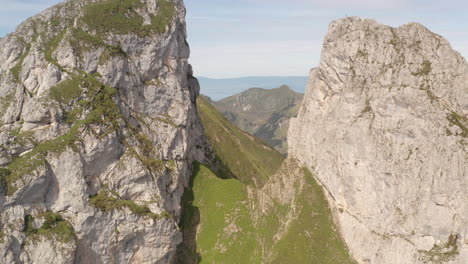 flying between large rocks on mountain top and revealing beautiful valley