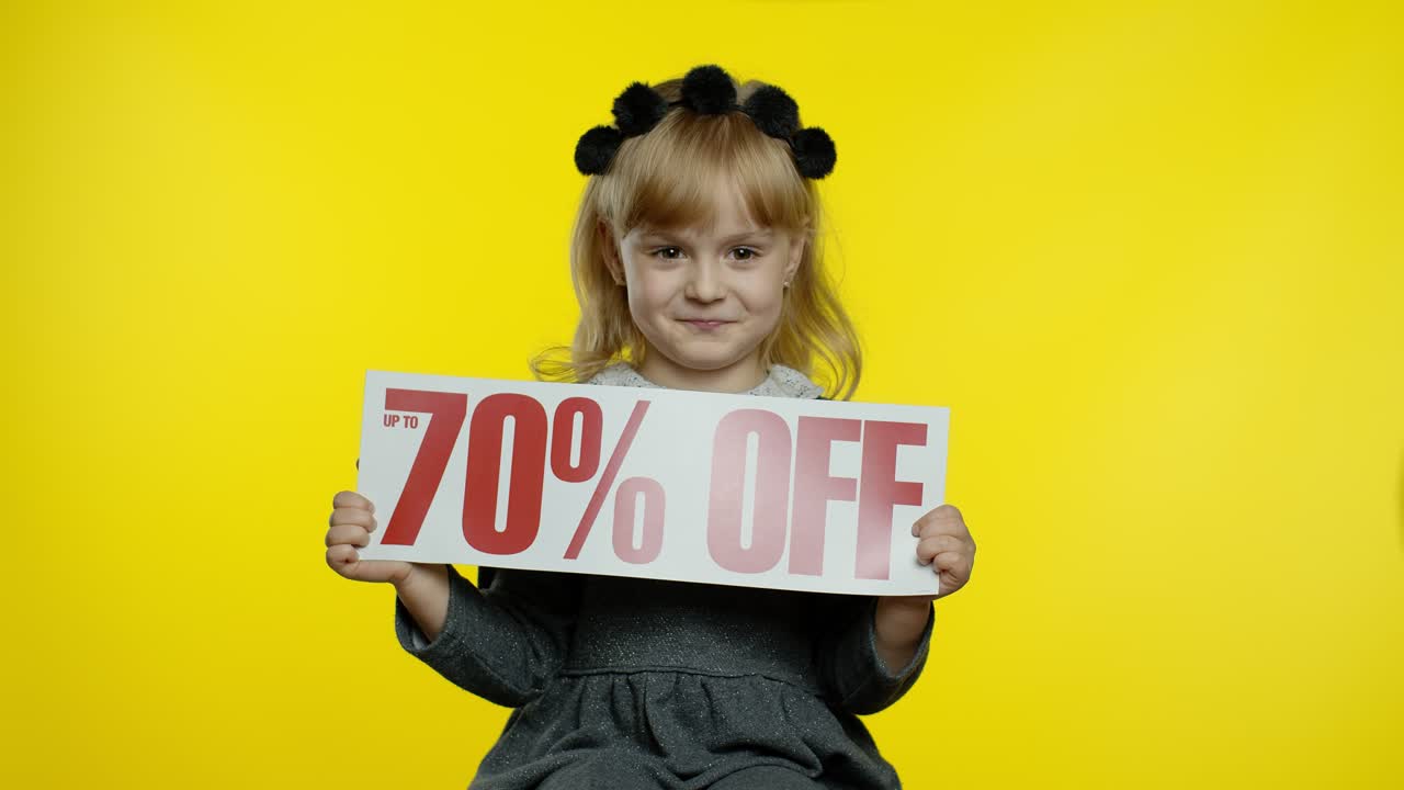 niña mostrando hasta un 70 por ciento de descuento en la inscripción, regocijándose en los descuentos para las ventas de compras en línea
