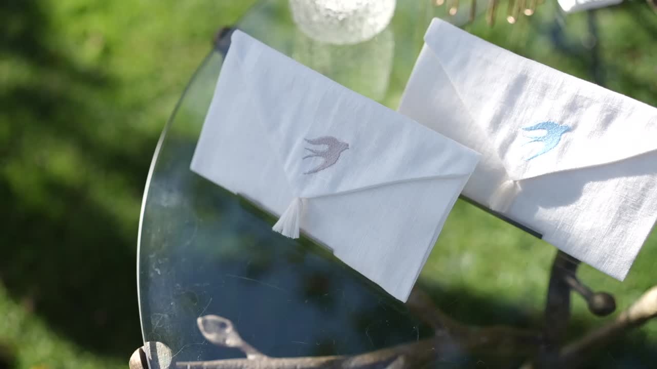 Primo piano di piccole buste bianche con icona a forma di uccello all'aperto