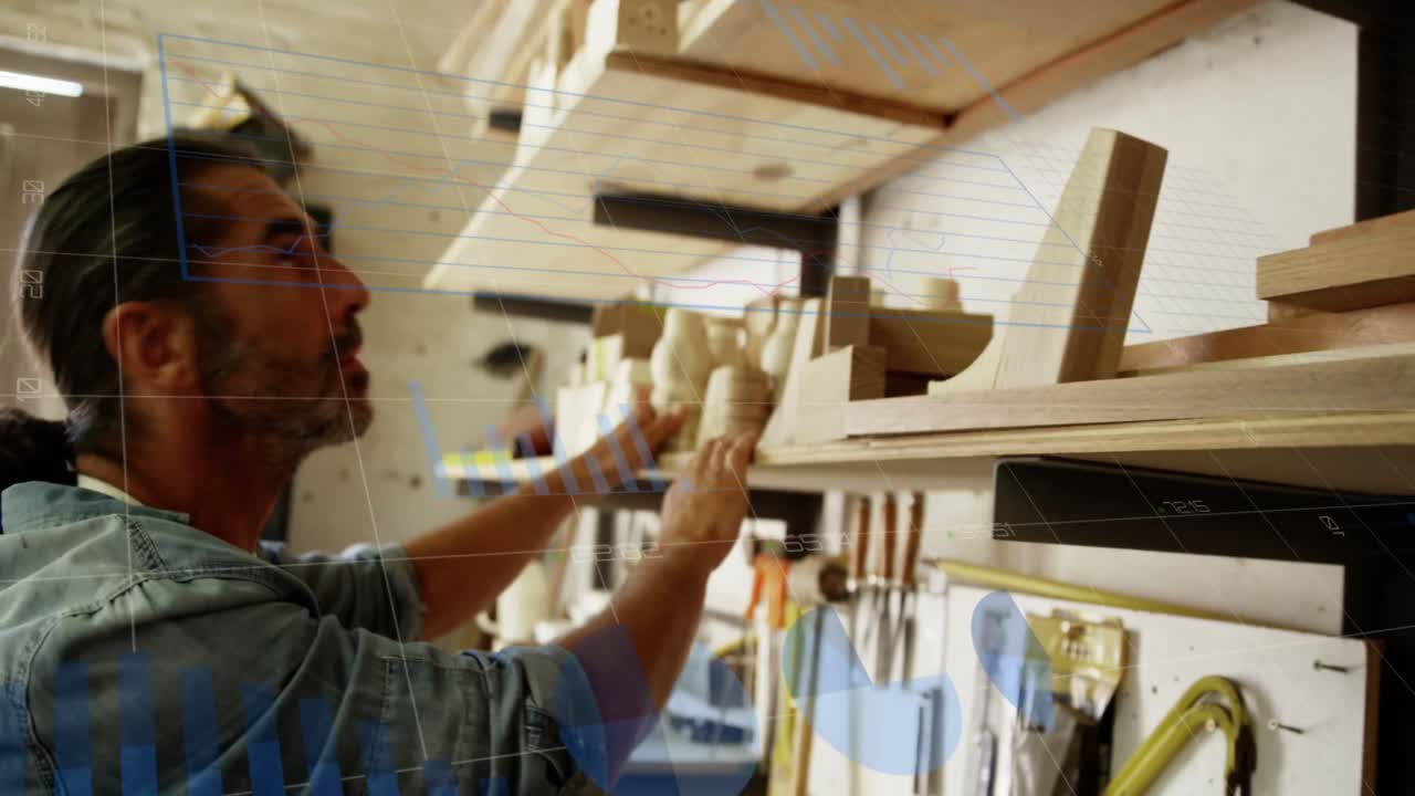 Animation of financial graphs over caucasian man searching for tools in carpentry workshop