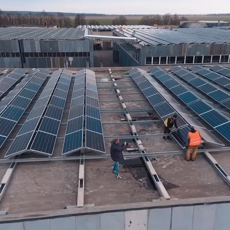 Powerful station with solar panels. Aerial shot of worker installing and working on maintenance of photovoltaic panel system