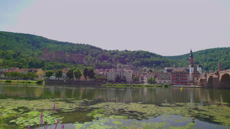 Heidelberg-view-of-Karl-Theodor-Brücke-bridge-with-castle-palace-chateau-with-Heiliggeistkirche,-river-neckar,-Brückentor,-Bridge-gate-on-a-sunny-day