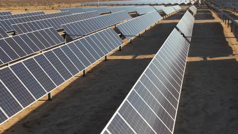 vuelo aéreo sobre filas de paneles fotovoltaicos en la planta solar en el desierto de mojave