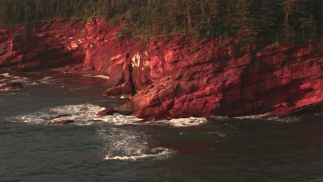 aerial view of red cliffs and ocean waves