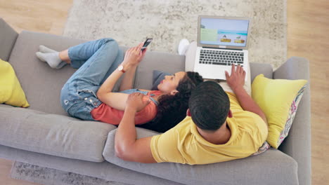 computadora portátil, planificación de vacaciones y una pareja en un sofá