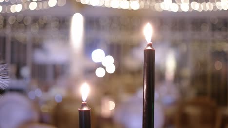 close up of lit candles with a soft bokeh effect in a warm, elegant setting