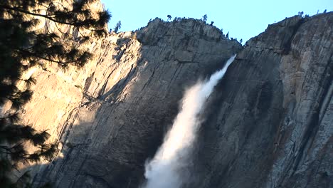 this goldenhour view of a waterfall shows the shadow of the spray as it plummets downward