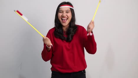happy young indonesian female standing holding red white flag to celebrates indonesia independence day