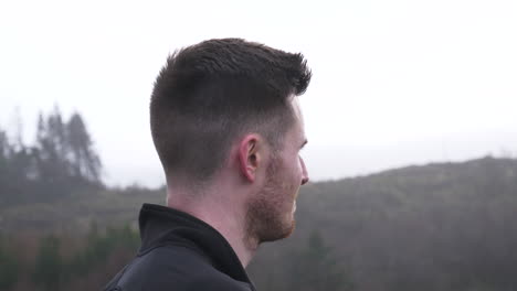 side profile of active hiking man overlooking dramatic landscape