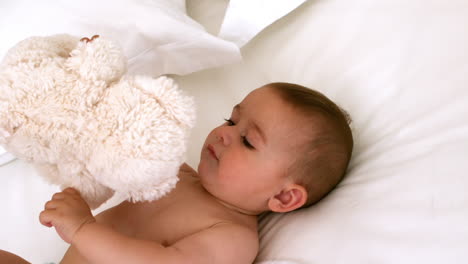 Süßes-Baby-Auf-Einem-Bett-Mit-Teddybär