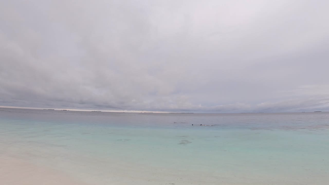 Tropical seashore, peaceful seascape with people swimming on a warm evening