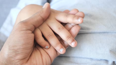 Father-holding-hand-of-baby-child,-close-up