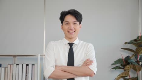 portrait of happy asian business man executive standing with arms crossed