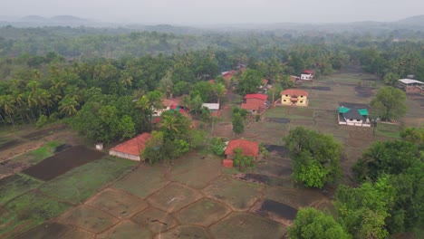 a mesmerizing 4k drone view of avalegaon, kudal village in konkan, maharashtra, india, showcasing its charm with traditional houses, lush green trees, vast fields and mountains under a pink sky