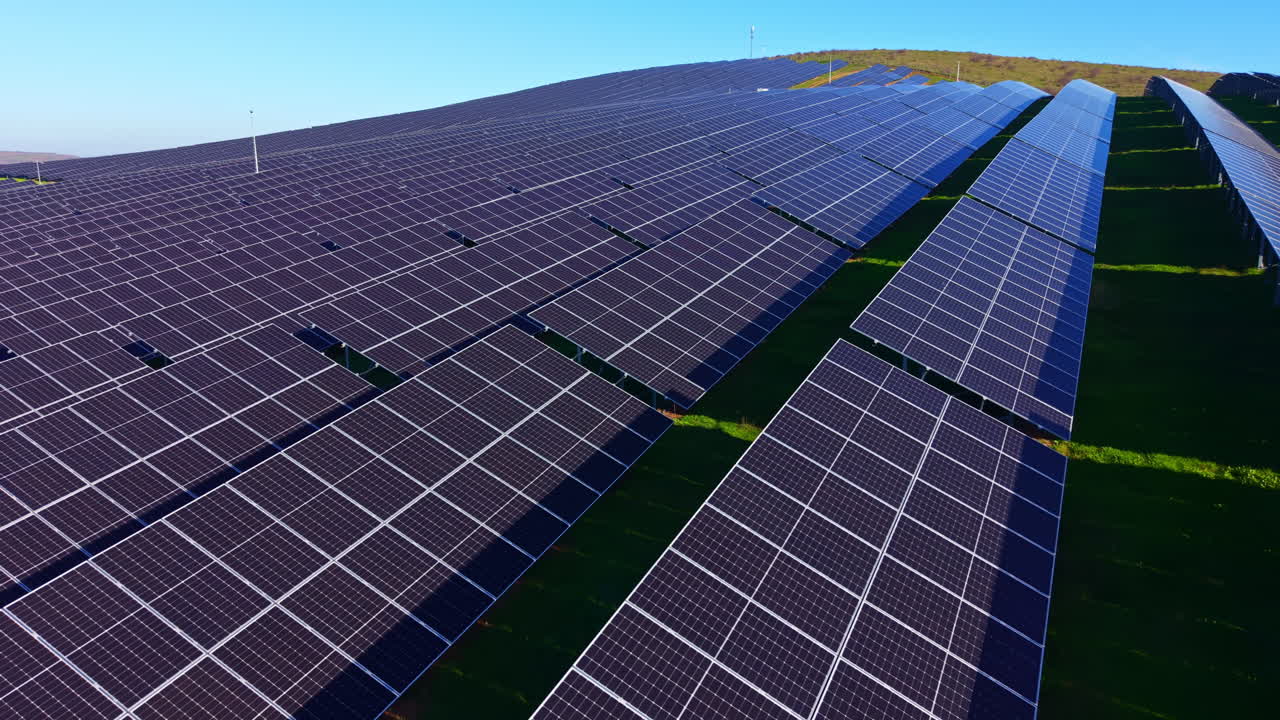 Stort solcellepanelområde, der udnytter sollys under en klar, blå himmel midt på dagen