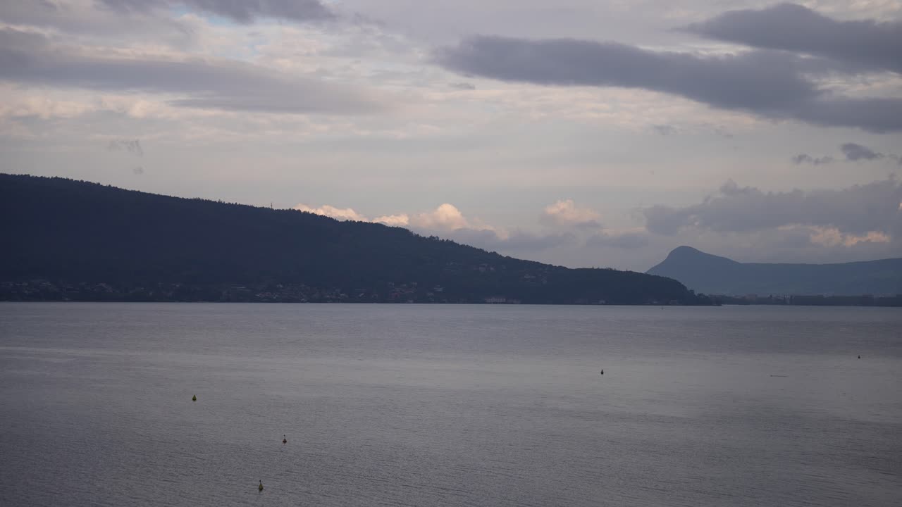 озеро аннеси в облачный день во французских альпах с далекими горами, правый снимок
