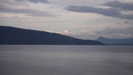 See-Von-Annecy-An-Einem-Bewölkten-Tag-In-Den-Französischen-Alpen-Mit-Fernen-Bergen,-Schwenk-Nach-Rechts