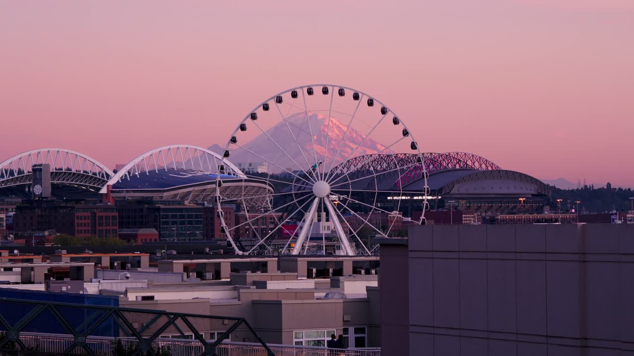 Seattle's ferris wheel slowly moving with Mount Rainier framed in the backdrop.