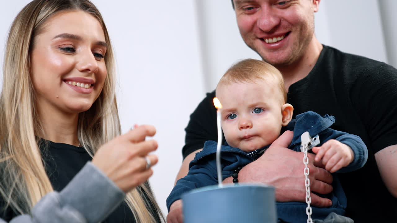 Caucasian family of three celebrating the holiday. Blonde woman lighting the candle on the cake. Close up.