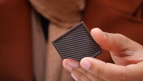 hand holding a piece of dark chocolate