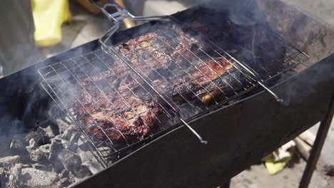 Meat-grilled-on-the-grid.-Food-for-barbecue-party.-Male-hand-is-turning-the-grid-around.-Meat-on-a-grill.-shot-in-4k