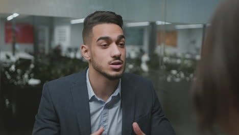 young man in suit talking in an office setting