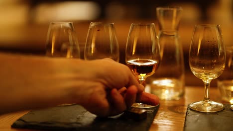 hand selecting whisky glass from a tasting set