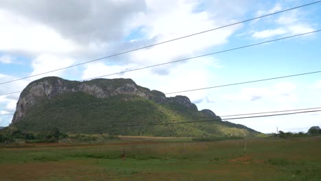 Viñales-Valley-view-from-a-moving-car,-Mogotes,-mountains,-farmer-houses,-cuban-land-scape