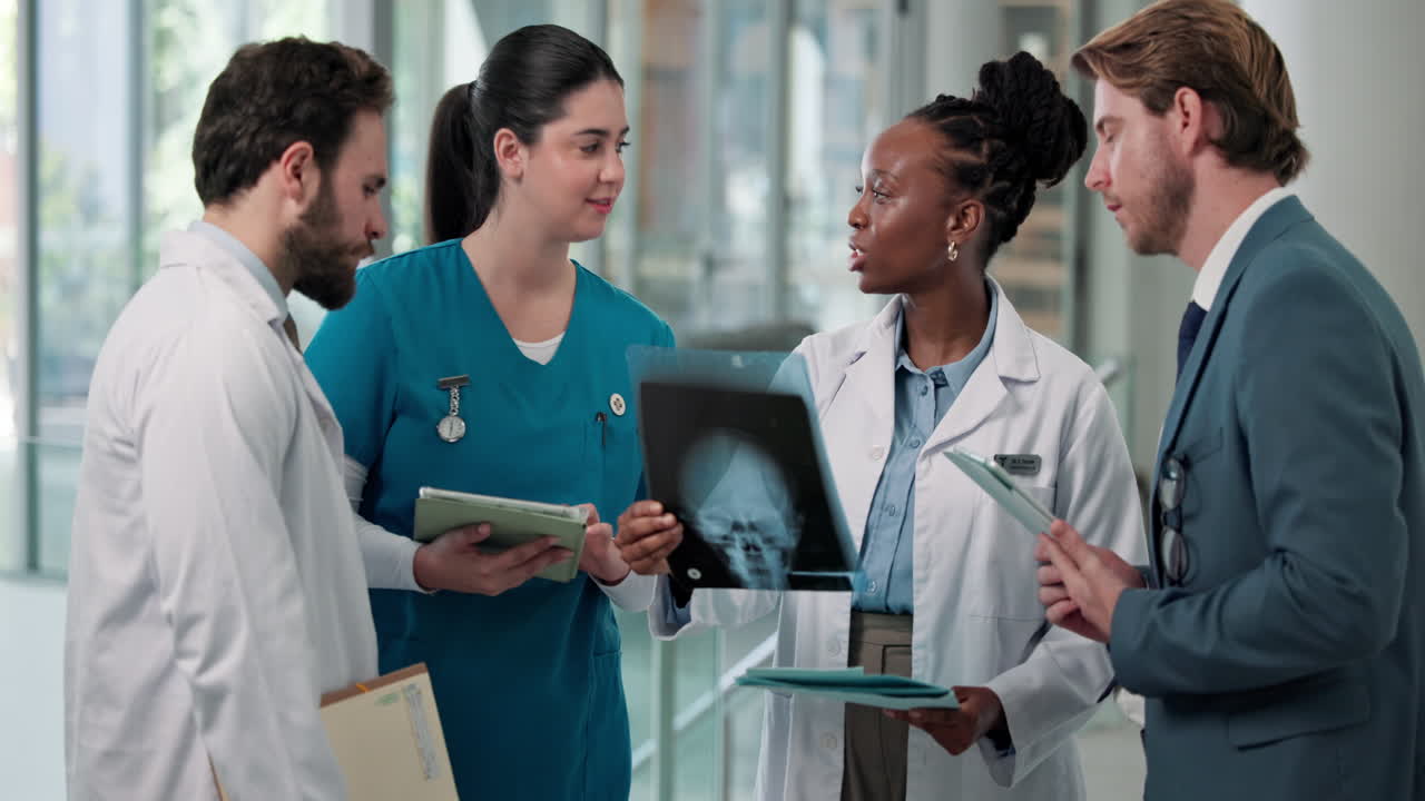 Medical Team Discussing X-Ray Scan in Hospital Corridor