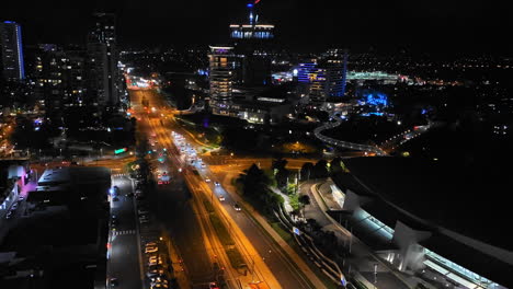 4k uhd time-lapse of car traffic on road and people crossing street at night in downtown broadbeach district, gold coast australia, aerial view