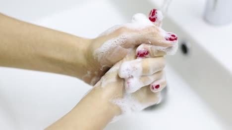 a person's hands are thoroughly washed with soap and water in a white sink