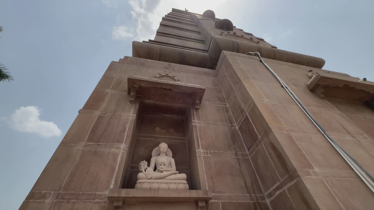 crane up of stone statue of buddha at sarnath temple, Sarnath is a significant Buddhist site where the Buddha delivered his first sermon
