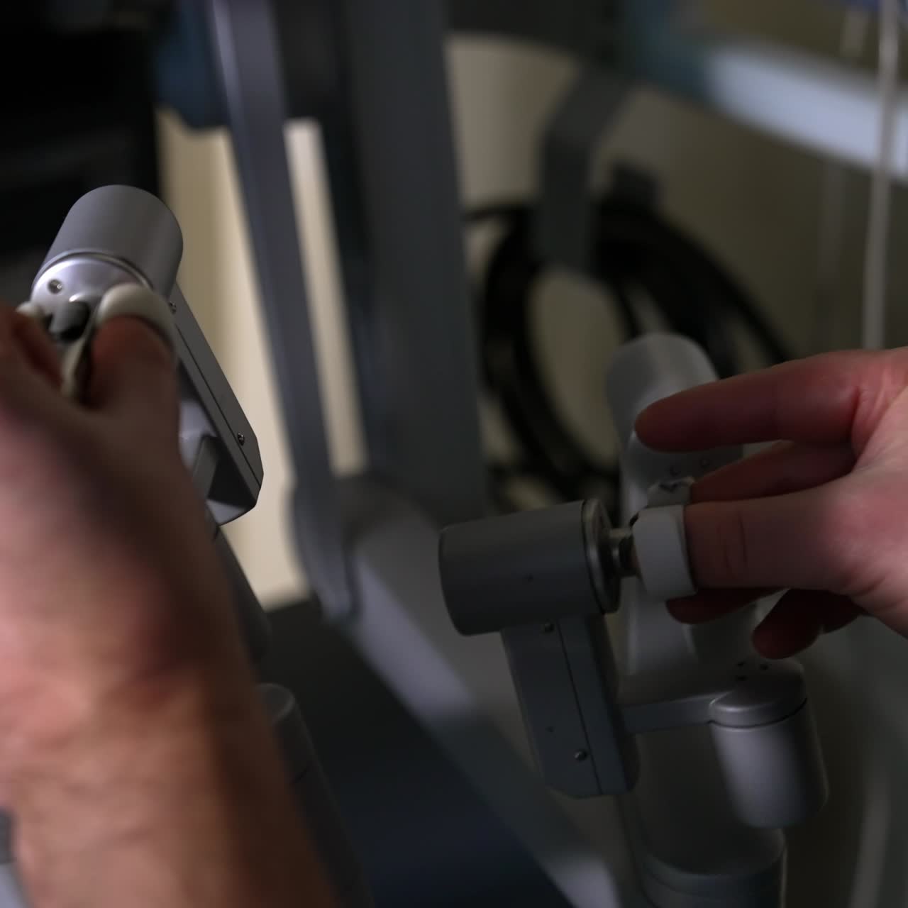 Human surgeon manipulating robotic surgery system. Doctor moves the handles in diverse directions. Close up