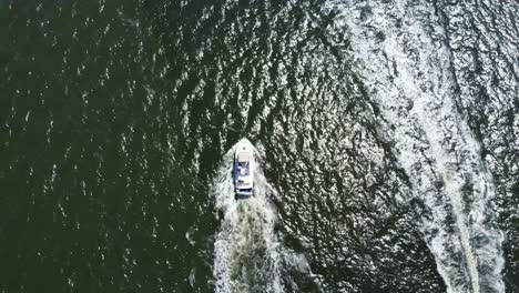 birds eye view straight down drone shot following a motor boat as it passes another boat going the other direction