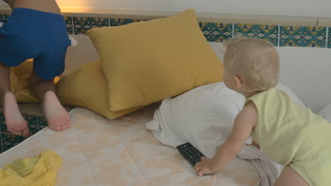 A-boy-playing-with-his-baby-sister-on-two-white-mattresses