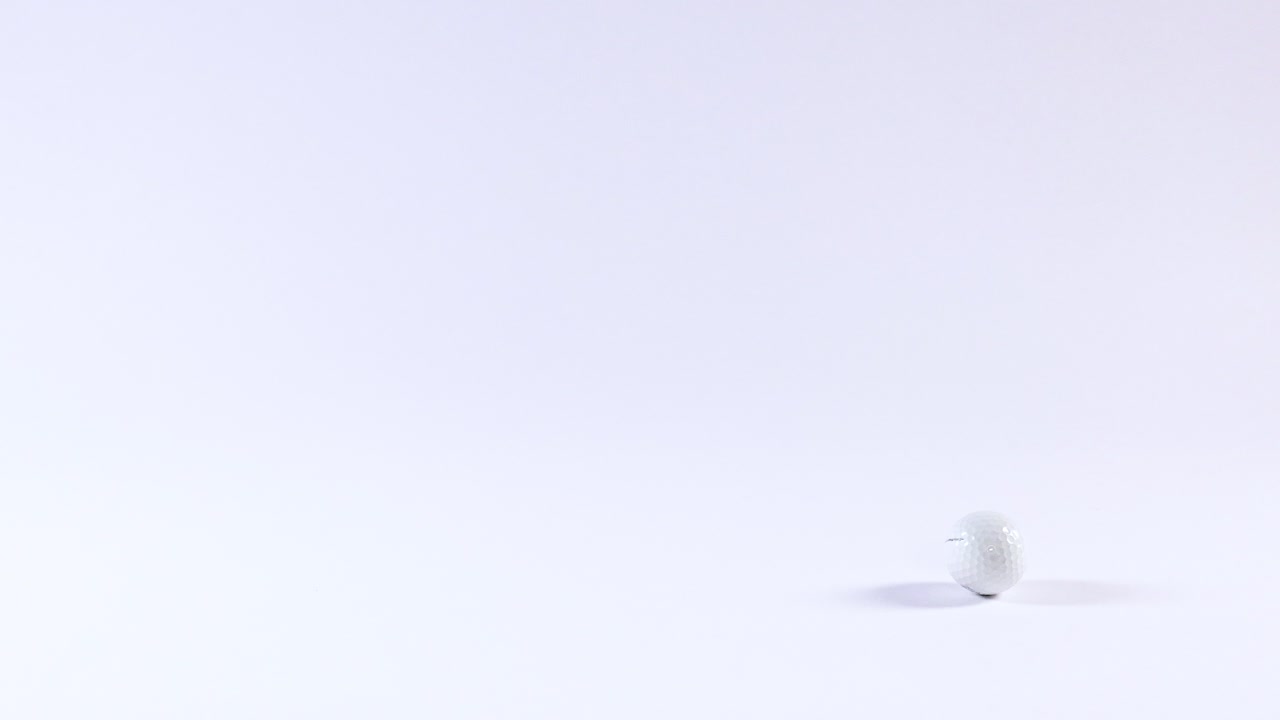 A golf ball moves across a white background
