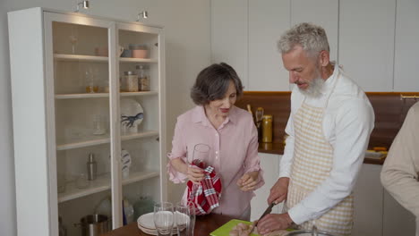 older man and woman friends cooking and talking in the kitchen