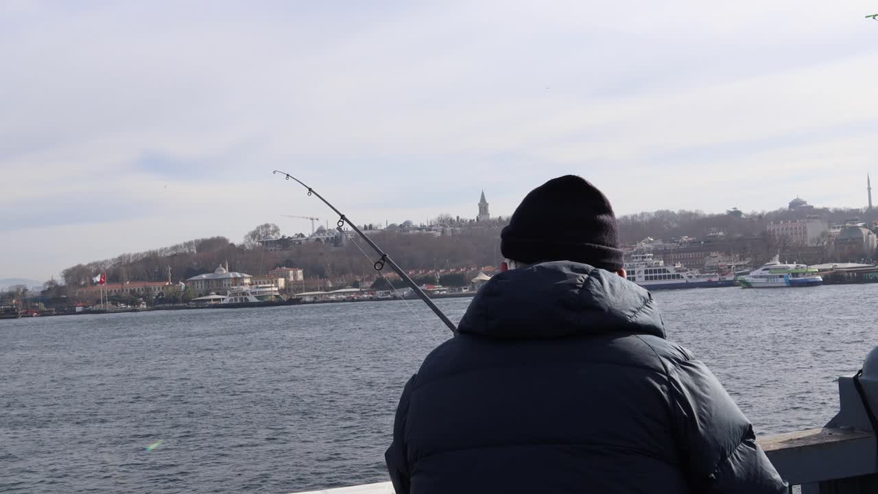 Uomo che pesca sul Ponte di Galata a Istanbul, Turchia