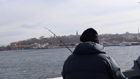 man fishing in galata bridge at istanbul, turkey