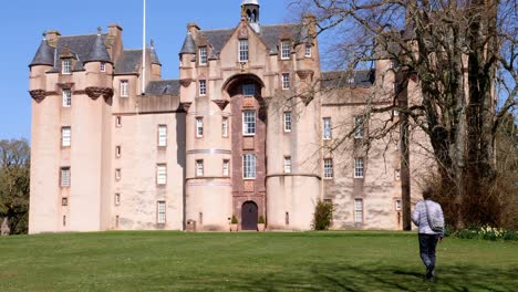 lady walker camina hacia el frente del castillo de fyvie en una hermosa mañana de primavera