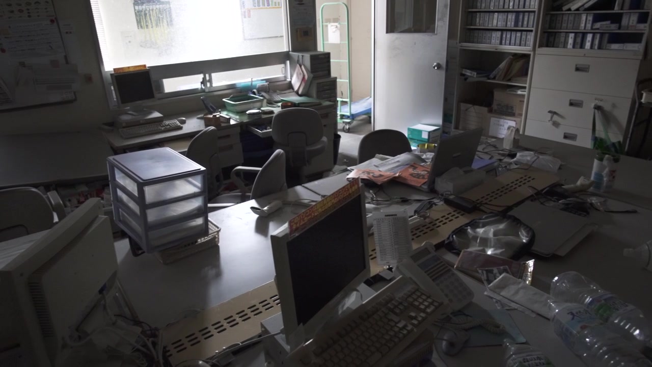 Slow pan across a messy, abandoned office frozen in time in Fukushima, Japan.