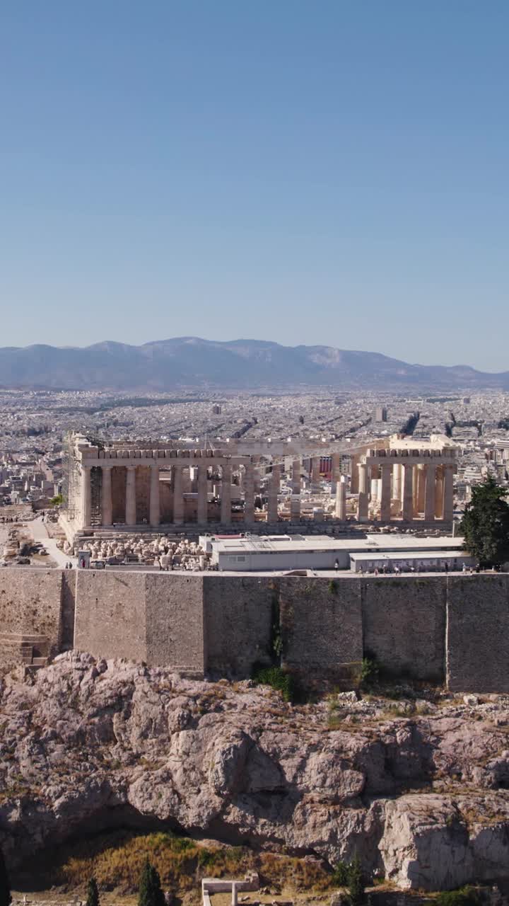 Vertical drone orbiting the majestic Parthenon in Athens, Greece, highlighting its classical architecture atop the Acropolis